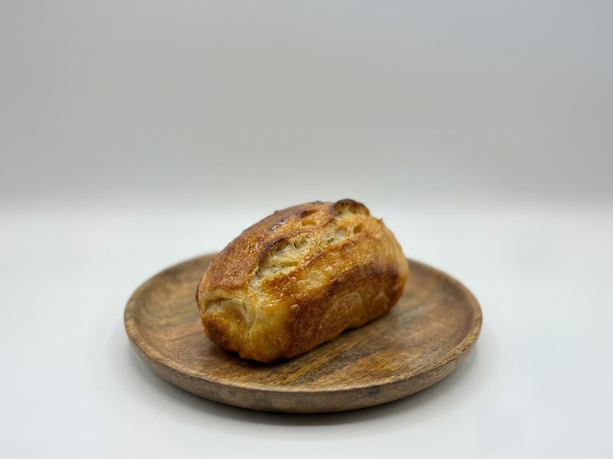 A butter sourdough loaf on a wooden plate